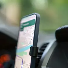 Smartfon z mapą na ekranie, zamontowany w samochodzie. To darmowa nawigacja samochodowa, która ułatwia podróżowanie.