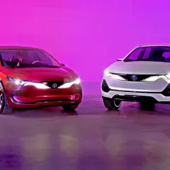 Dwa samochody Izera: czerwony sedan i biały SUV, prezentują nowoczesny design na tle fioletowego tła.