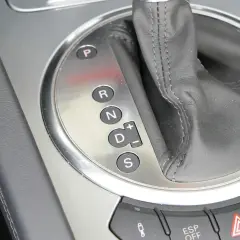 Zbliżenie na panel z oznaczeniami automatycznej skrzyni biegów: P, R, N, D (z możliwością ręcznej zmiany biegów +/–) oraz S (Sport).