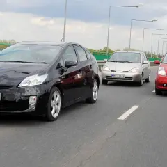 Trzy japońskie auta jadące w kolumnie: czarny, srebrny i czerwony.