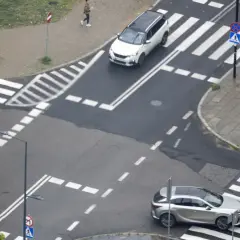 Na skrzyżowaniu równorzędnym dwa samochody zbliżają się do pasów.