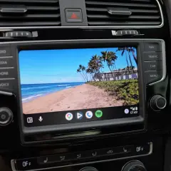 Samochód z ekranem Android Auto aktualizacja. Widok na tropikalną plażę z palmami.