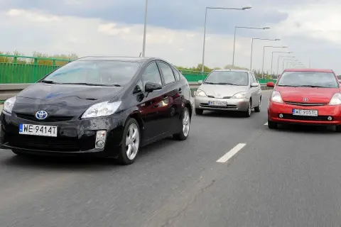 Trzy japońskie auta jadące w kolumnie: czarny, srebrny i czerwony.