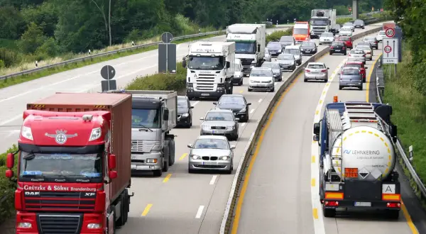 Ruch na autostradzie z wieloma ciężarówkami i samochodami osobowymi.