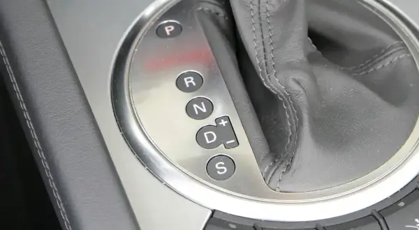 Zbliżenie na panel z oznaczeniami automatycznej skrzyni biegów: P, R, N, D (z możliwością ręcznej zmiany biegów +/–) oraz S (Sport).
