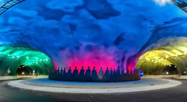 Kolorowy tunel z sylwetkami ludzi, oświetlony na zielono, różowo i żółto. To nie jest najdłuższy tunel na świecie, ale robi wrażenie.