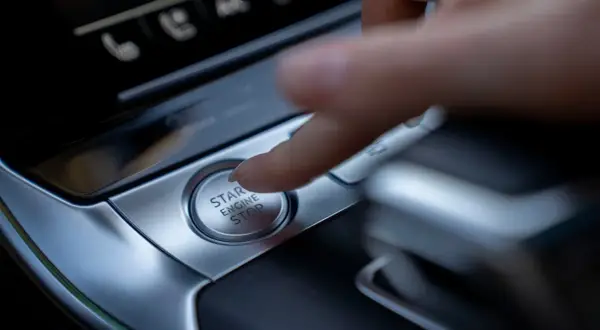 Palec naciska przycisk "START ENGINE STOP", rozpoczynając lub kończąc podróż.