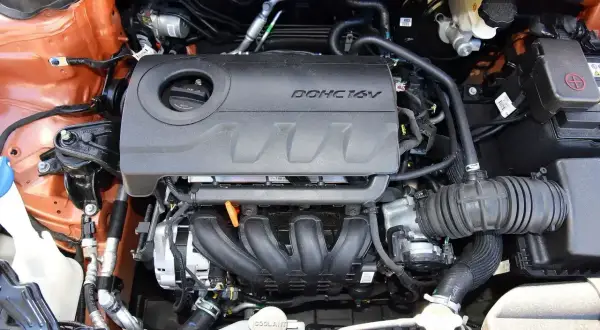 Silnik DOHC 16V 1.6 GDI w samochodzie. Widoczne elementy układu dolotowego i chłodzenia.