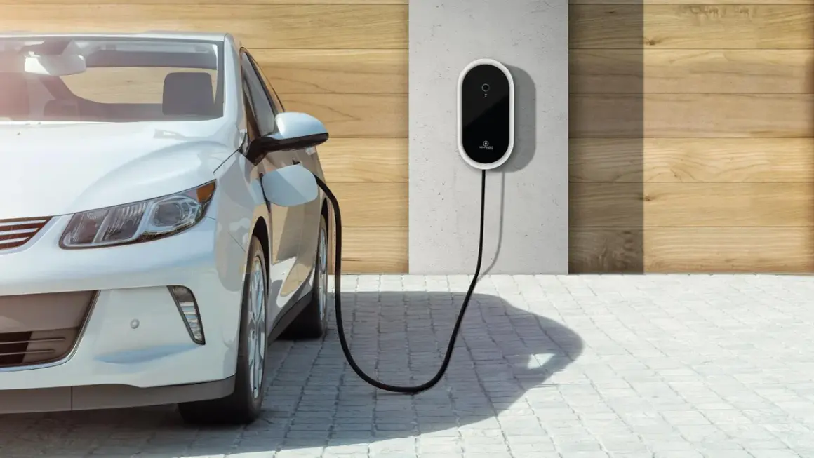 Biały samochód elektryczny podłączony do ładowarki ściennej. Czysta energia dla przyszłości.