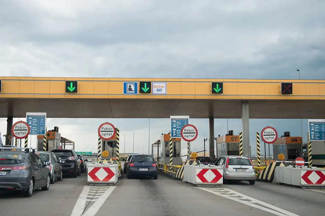 Kolejka samochodów na autostradzie A1 przy punkcie poboru opłat. Zielone strzałki wskazują otwarte bramki.