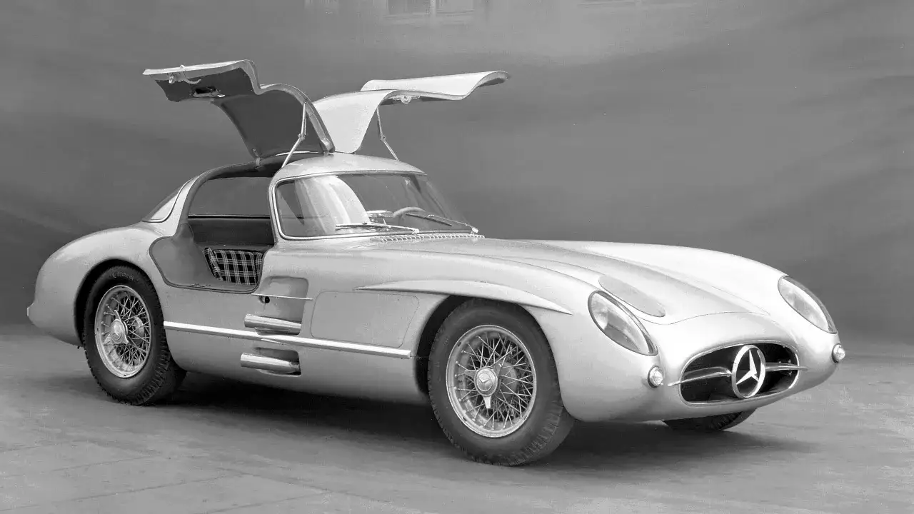 Srebrny Mercedes-Benz 300 SLR Uhlenhaut Coupé, najdroższe auto na świecie, z otwartymi drzwiami typu gullwing.