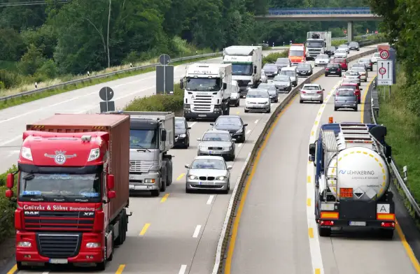 Ruch na autostradzie z wieloma ciężarówkami i samochodami osobowymi.