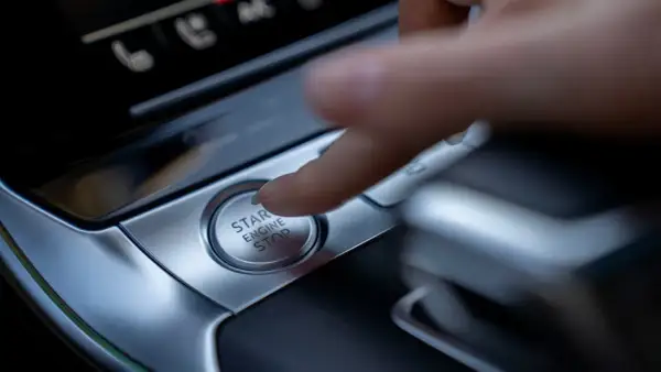 Palec naciska przycisk "START ENGINE STOP", rozpoczynając lub kończąc podróż.
